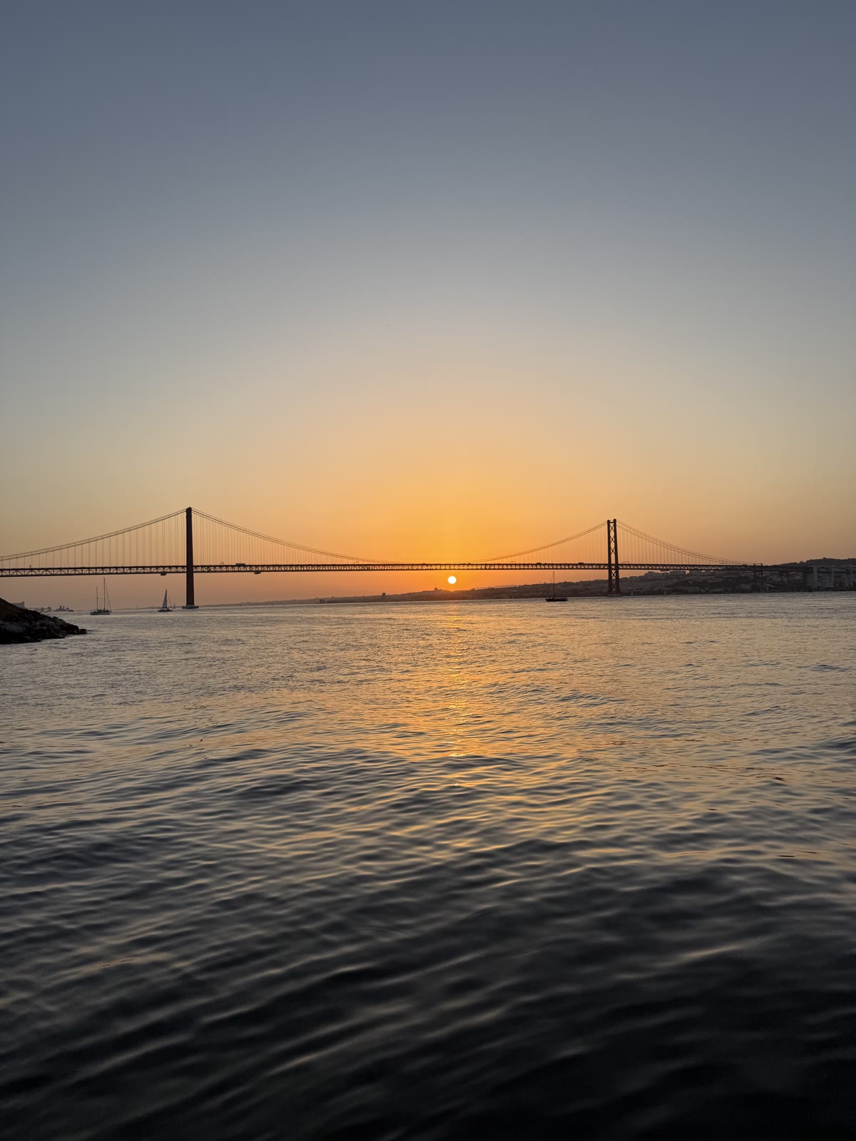 The 25 de Abril bridge at sunset over the Tagus
