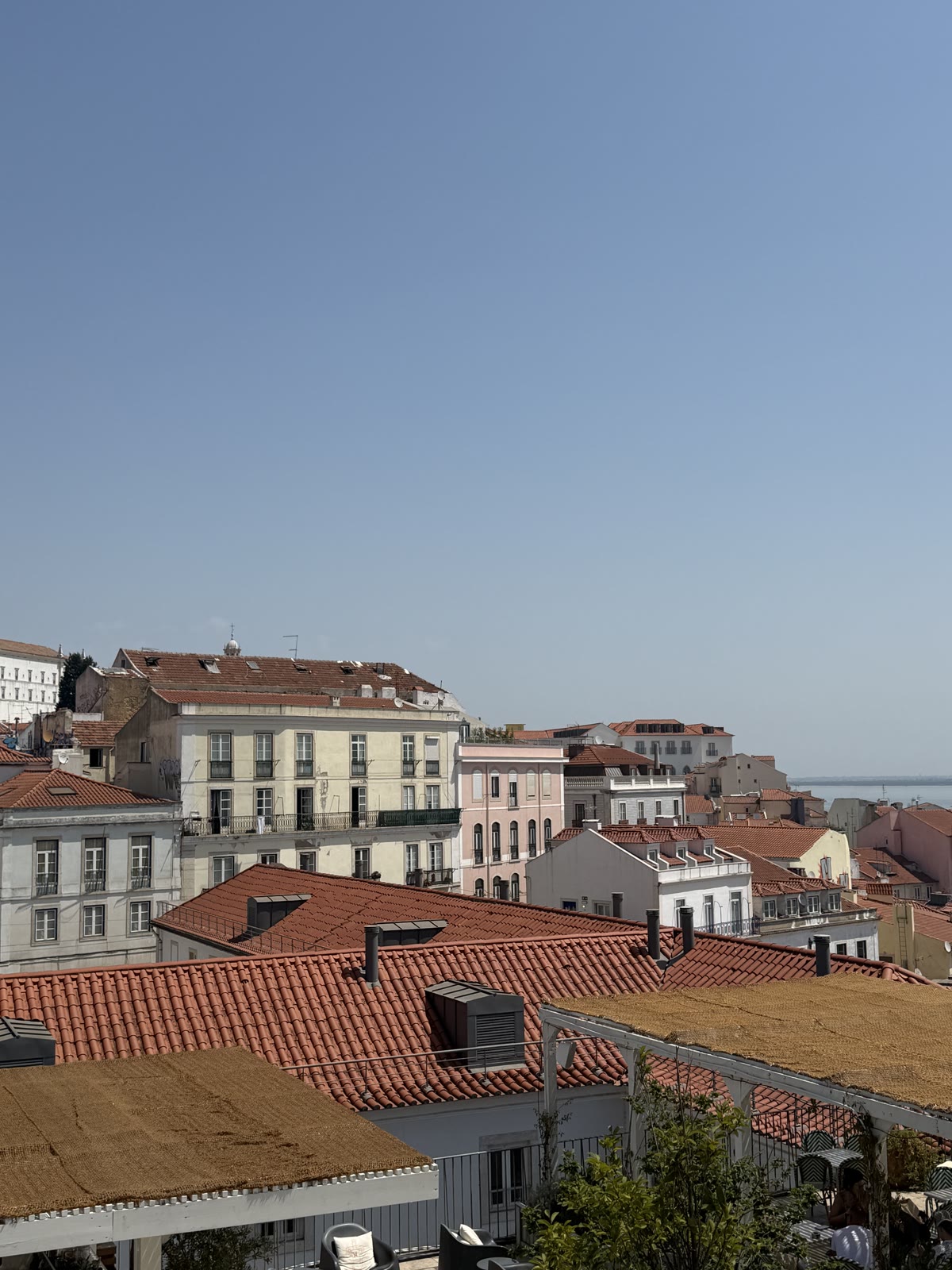 Terracotta rooftops descending toward the water in Lisbon